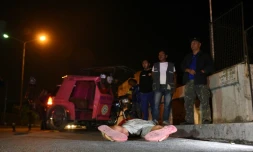 Des villageois observe un corps à Quezon City, près de Manille, aux Philippines, le 9 mars 2017