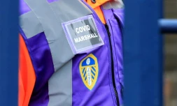 Un Covid Marshall chargé de surveiller le statut sanitaire des supporters à leur arrivée au stade de Leeds avant un match de Premier League contre Arsenal le 18 décembre 2021