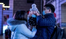 En Chine, des parents mettent un masque protecteur à leur bébé à Pékin, le 23 janvier 2020