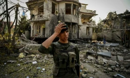 Un membre du personnel de sécurité afghan monte la garde sur le site, un jour après l'explosion d'une voiture piégée à Kaboul, le 4 août 2021