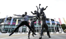 Un homme devant les statues de joueurs de rugby devant le stade Twickenham le 17 septembre 2015 à Londres 