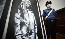 L'oeuvre de Banksy volée au Bataclan, ici surveillée le 11 juin 2020 par un policier à L'Aquila, en Italie, après avoir été retrouvée dans une ferme abandonnée