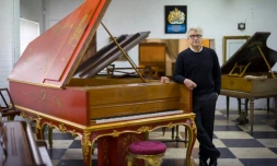 David Wilson, collectionneur et restaurateur de pianos, à côté d'un rare piano Pleyel datant de 1925, dans son atelier de Biddenden, le 6 août 2021 dans le sud-est de l'Angleterre
