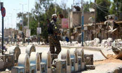 Un combattant des Forces démocratiques syriennes dans une rue de Tabqa, le 12 mai 2017, lors de l'avancée des forces de la coalition vers Raqa, fief des jihadistes de l'EI