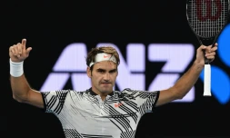 Le Suisse Roger Federer bras levés après sa victoire face à son compatriote Stan Wawrinka en demi-finales de l'Open d'Australie, le 26 janvier 2017 à Melbourne