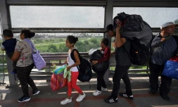 Des migrants traversent le pont de Matamoros-Brownsville après avoir obtenu un rendez-vous auprès des services de l'immigration américains afin d'entrer légalement sur le territoire des Etats-Unis, le 12 mai 2023 à Matamoros (Nord du Mexique)