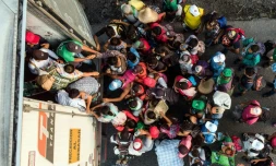 Des migrants honduriens montent Ă bord d'un camion, prĂšs de Pijijiapan, dans le sud du Mexique le 26 octobre 2018