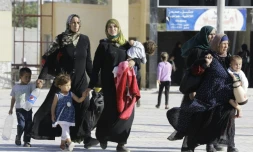 Des Syriens qui ont fui avec leurs familles des zones contrôlées par l'EI à Raqa, se rassemblent à la gare routière d'Alep de Ramussa, le 4 juillet 2017