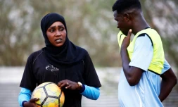 La Soudanaise Salma al-Majidi, premiÚre coach d'un club de foot, parle avec un joueur du club régional Al-Ahly, le 17 février 2018 à Al-Gadaref, à l'est de Khartoum
