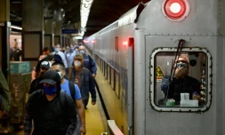 Des voyageurs sortent d'une rame de métro à la station de Grand Central, à Manhattan, le 8 juin 2020, premiÚre jour du début de déconfinement à New York