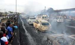 Des passants observent les ravages causés par l'incendie déclenché par l'explosion d'un camion-citerne à Lagos le 28 juin 2018.