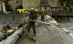 Des équipes de secours enlèvent des arbres tombés sur un pont à Breil-sur-Roya (sud-est de la France), le 4 octobre 2020
