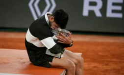 L'Espagnol Carlos Alcaraz enlace le trophée de Roland-Garros après sa victoire en finale sur l'Italien Jannik Sinner, le 8 juin 2025 à Paris