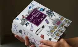 Une femme tient dans sa main un exemplaire du Petit Larousse illustré 2016, le 18 mai 2015 à Paris