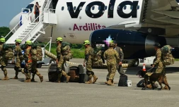 Des militaires salvadoriens accompagnés de chiens renifleurs se préparent à embarquer à bord d’un avion à destination du Venezuela, sur la base aérienne de Comalapa à San Luis Talpa, au Salvador, le 25 juin 2026