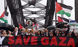 Des manifestants, dont le fondateur de WikiLeaks, Julian Assange (3e en partant de la gauche, l'homme portant une cravate rouge), défilent sur le pont Harbour Bridge à Sydney lors d’un rassemblement pro-palestinien le 3 août 2025.