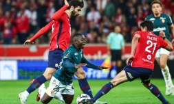 Le défenseur de Lens Nampalys Mendy (centre) chute après un duel avec les Lillois Angel Gomes (gauche) et Benjamin André (droite), lors de la 27e journée de L1, le 30 mars 2025 au stade Pierre-Mauroy 