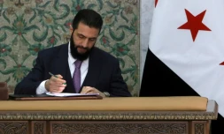 Le président par intérim de la Syrie, Ahmad al-Chareh, signe la déclaration constitutionnelle du pays, au palais présidentiel de Damas, le 13 mars 2025