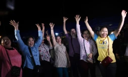 Des bénévoles célèbrent l'évacutaion des jeunes gens bloqués 18 jours dans une grotte inondée, à Mae Sai, en Thaïlande, le 10 juillet 2018