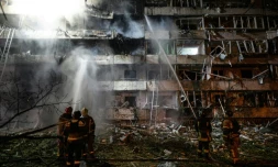 Des pompiers sur le site d'une frappe de missile russe contre un immeuble résidentiel à Kiev, le 14 octobre 2026 en Ukraine
