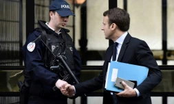 Emmanuel Macron salue un policier en sortant de chez lui, le 26 avril 2017 à Paris