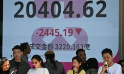 Des personnes se tiennent devant un écran de l'indice boursier Heng Seng de la Bourse de Hong Kong le 7 avril 2025