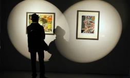 Un homme regarde des dessins d'auteurs américains de comics lors du festival de BD d'Angoulême le 26 janvier 2012