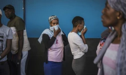 Des clients d'un supermarché font la queue à l'extérieur à Johannesburg, le 27 mars 2020