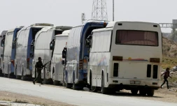 Convoi évacuant des rebelles et des civils de la Ghouta Orientale le 26 mars 2018 à l'entrée d'Harasta en périphérie de Damas (Syrie)