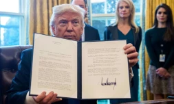 Le président Donald Trump montre l'un des décrets qu'il vient de signer, le 24 janvier 2017 dans le Bureau Ovale de la Maison Blanche, à Washington