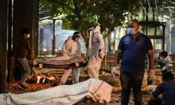 Des proches et du personnel soignant transportent vers un crematorium le corps d'une personne décédée du Covid-19, à New Delhi (Inde) le 22 avril 2021