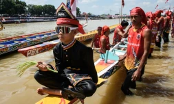 Rayyan Arkan Dikha assis à l'avant d'un bateau avant une course nautique traditionnelle, le 22 août 2025 sur la rivière Kuantan, dans la province indonésienne de Riau, sur l'île de Sumatra 