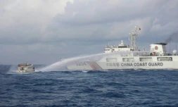 Photo diffusée, le 10 décembre 2023, par les garde-cÎtes philippins d'un navire des garde-cÎtes chinois (d) tirant au canon à eau contre un bateau de ravitaillement philippin en mer de Chine méridionale disputée