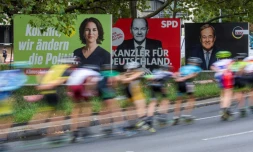 Des skaters passent devant des panneaux électoraux des trois principaux candidats à la succession de la chancelière allemande Angela Merkel, le 25 septembre 2021 à Berlin