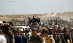 Des Palestiniens revenant d'un site de distribution d'aide de la Fondation humanitaire à Gaza (GHF) soutenue par Israël et les Etats-Unis, dans le centre de la Bande de Gaza, le 3 août 2025
