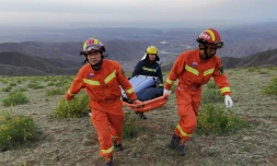 Des sauveteurs transportent du matériel pour secourir des coureurs pris dans de fortes intempéries, prÚs de Baiyin, le 22 mai 2021 dans le nord-ouest de la Chine