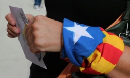 Une femme, un foulard indépendantiste au poignet, dans un bureau de vote de Badalona en Espagne, le 27 septembre 2015