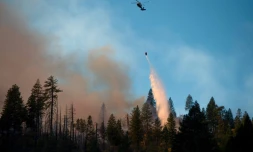Un hélicoptère déversant de l'eau pour lutter contre l'incendie "Camp fire", à l'est de la ville de Paradise, en Californie, le 11 novembre 2018