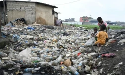 Des enfants jouent au milieu de déchets en plastique à Anyama, près d'Abidjan, le 25 mai 2023