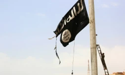 Dans cette photo prise le 30 avril 2017, on voit un combattant kurde retirer le drapeau du groupe jihadiste Etat islamique (EI) dans la ville de Tabqa, à quelque 55 km à l'ouest de Raqa, la capitale de l'EI en Syrie ensuite reprise par les forces kurdes aux jihadistes