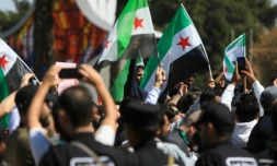 Forces de sécurité et manifestants syriens à Damas, le 15 mars 2025, pour le 14e anniversaire du soulèvement populaire de 2011