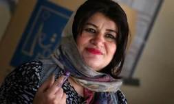 Une femme montre son doigt avec de l'encre dans un bureau de vote à Erbil, capitale du Kurdistan irakien (nord), le 12 mai 2018 lors des élections législatives