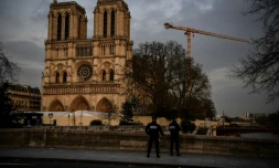 Des policiers patrouillent aux abords désertés de la cathédrale Notre-Dame de Paris, habituellement peuplés de touristes, le 17 mars 2020
