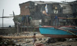 Un enfant au milieu d'une maison endommagée par le thyphon Nock-Ten le 26 décembre 2016 à Manille