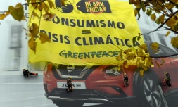 Des militants de Greenpeace ont déployé sur la façade d'un immeuble le 29 novembre 2019 à Madrid une énorme banderole : "Consumérisme=Crise climatique"