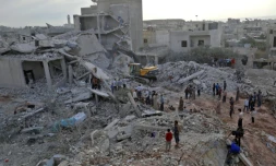 Des Syriens devant des maisons détruites par des raids attribués à la Russie à Zardana, une localité contrôlée par des jihadistes dans la province syrienne d'Idleb le 8 juin 2018