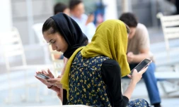 Des Afghanes consultent leurs smartphones à Shengjin, le 11 septembre 2021 en Albanie