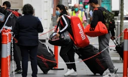 Joueurs de tennis et officiels arrivent à l'hÎtel Grand Hyatt, le 15 janvier 2021 à Melbourne, pour débuter une quarantaine de deux semaines, en raison des mesures sanitaires prises pour lutter contre le Covid-19, avant le début de l'Open d'Australie, le 8 février