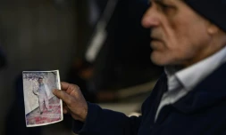 Le Turc Mehmet Erturk, tout juste libéré d'une prison syrienne, montre des photos lors d'un entretien avec l'AFP dans sa maison du village de Magaracik, le 13 décembre 2024 à Kilis, en Turquie