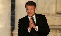 Le président français Emmanuel Macron salue le public à son arrivée sur scène lors d'un événement à l'Agora romaine d'Athènes, le 24 avril 2026 en Grèce